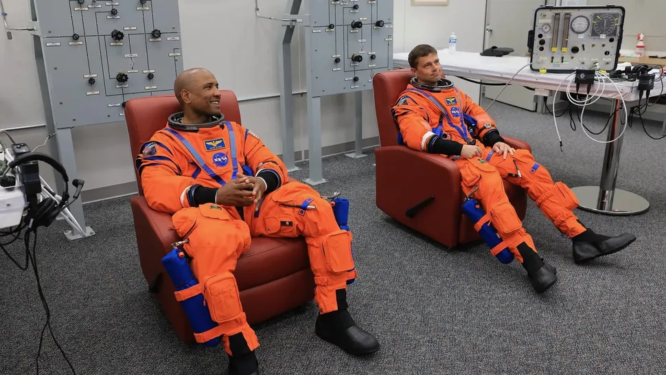 From left: NASA astronauts Victor Glover, Artemis II pilot, and Reid Wiseman, Artemis II commander, conduct leak checks on their spacesuits at NASA's Kennedy Space Center in Florida on April 1, 2026, ahead of the Artemis II launch. (Image credit: NASA/Kim Shiflett)